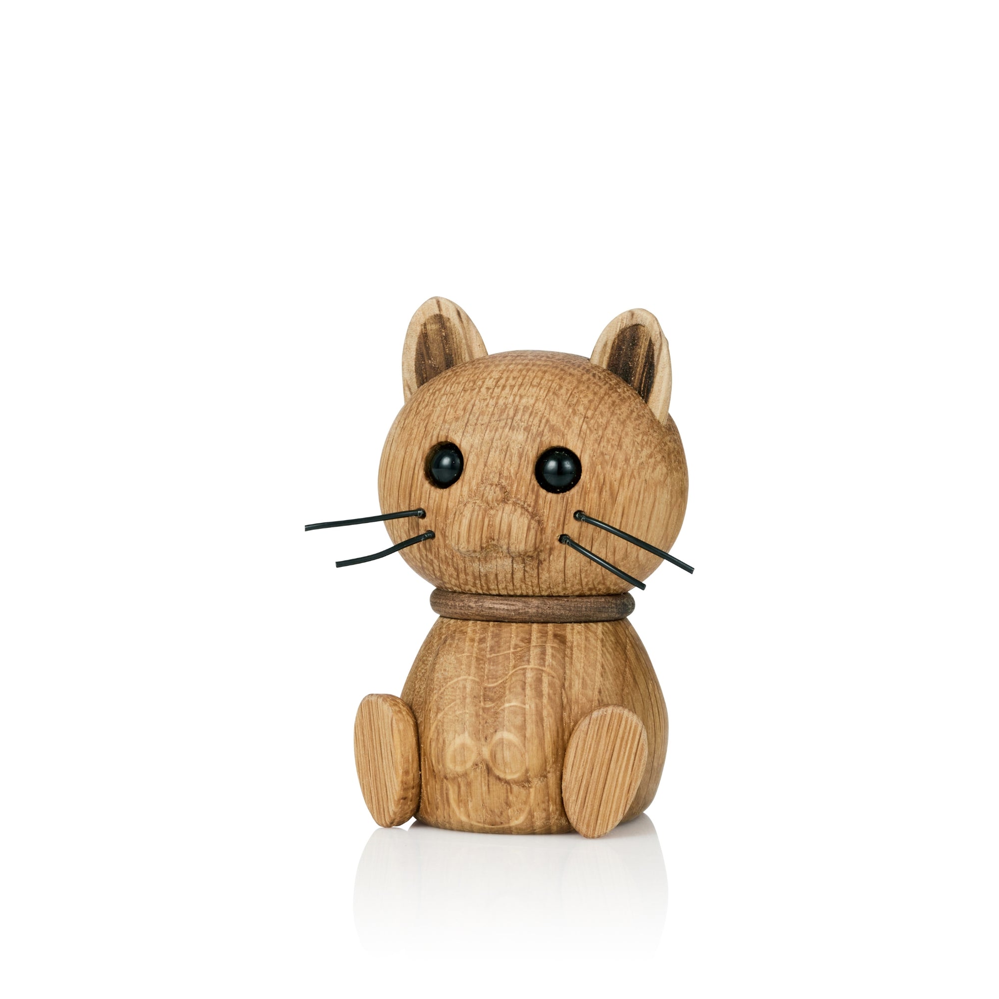 A wooden cat figurine with black eyes and whiskers, sitting upright.