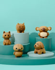 Wooden animal figurines on teal platforms against a teal background.
