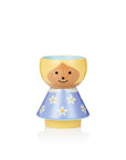 A wooden egg cup shaped like a girl with a yellow head and blue dress with white flowers.