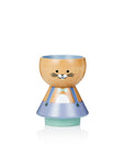 A wooden egg cup shaped like a cat, with a painted face and blue outfit.