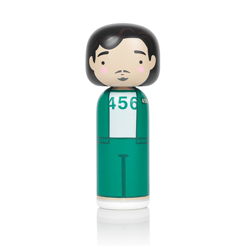 A kokeshi doll with black hair, wearing a green tracksuit with the number 456.