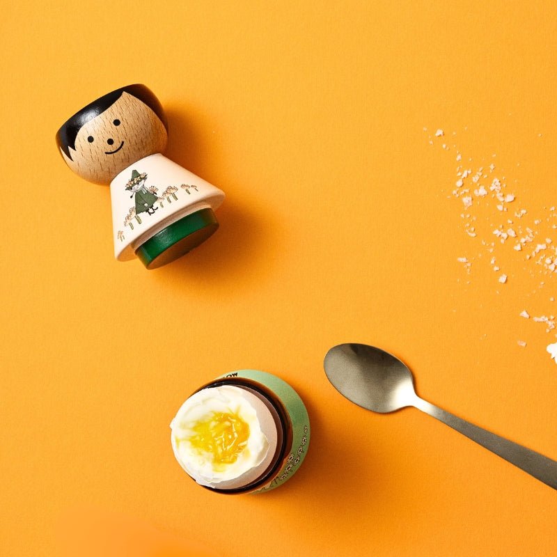 Egg Holder | Snufkin Free-spirited EGG HOLDER on yellow background with a soft boiled egg - Lucie Kaas