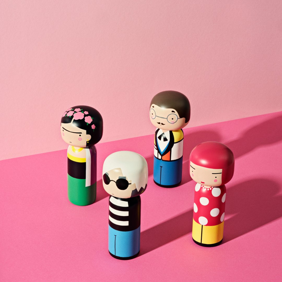 A selection of Lucie Kaas&#39; Kokeshi Dolls on a pink background