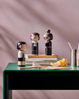 Et udvalg af Lucie Kaas' kvindelige Kokeshi-dukker på et bord i et interiør.