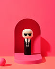 Karl Kokeshi-dukke foran en lyserød baggrund