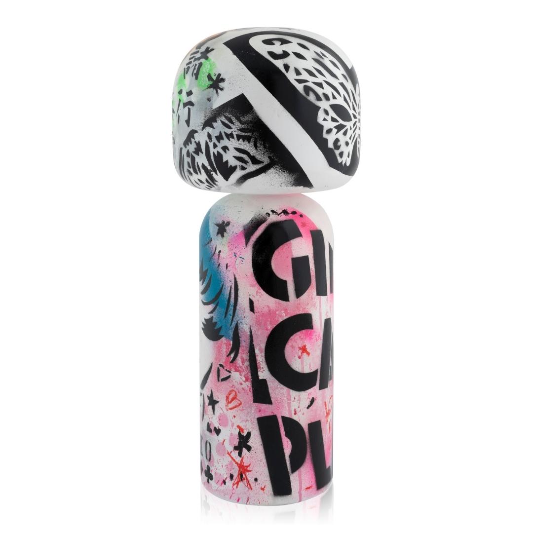 Eine bunte Kokeshi-Puppe mit Graffiti-Mustern und Text auf weißem Hintergrund.