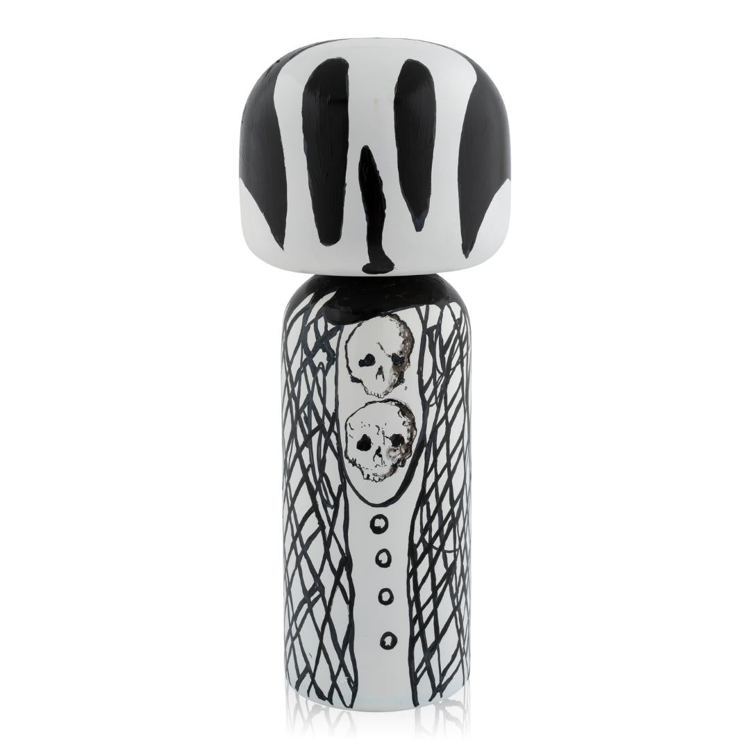 Schwarz-weiße Kokeshi-Puppe mit abstrakten Mustern und Totenkopfdetails.