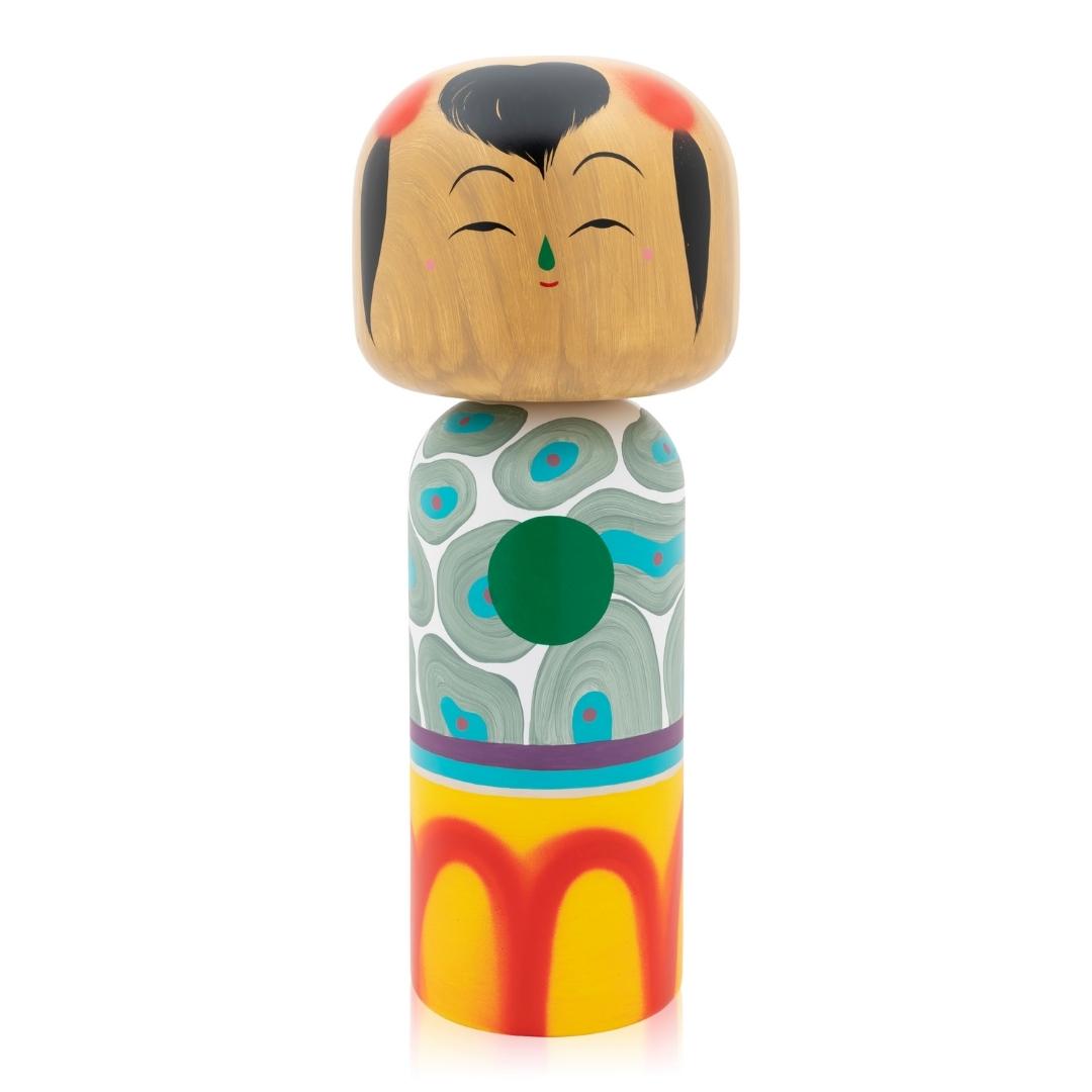 Eine bunte Kokeshi-Puppe mit bemaltem Gesicht und gemustertem Körper.