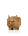 Eine hölzerne Schweinefigur mit kleinen Ohren und runden schwarzen Augen.
