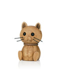 Eine hölzerne Katzenfigur mit schwarzen Augen und Schnurrhaaren, aufrecht sitzend.