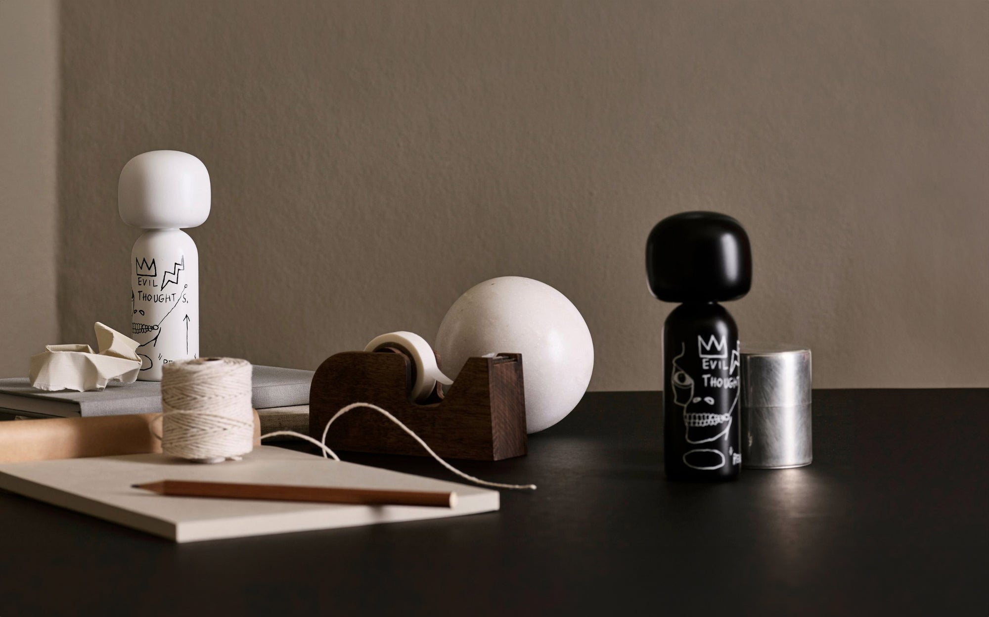 Kokeshi-Puppen und Dekorationsartikel auf einem Tisch mit neutralem Hintergrund.
