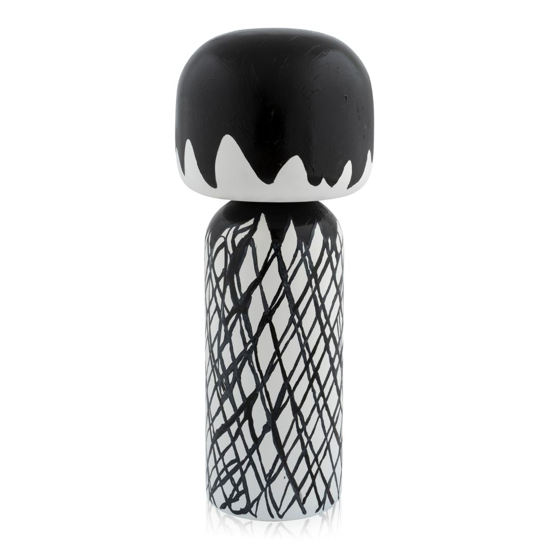 Schwarz-weiße Kokeshi-Puppe mit abstrakten Mustern und einem abgerundeten Oberteil.