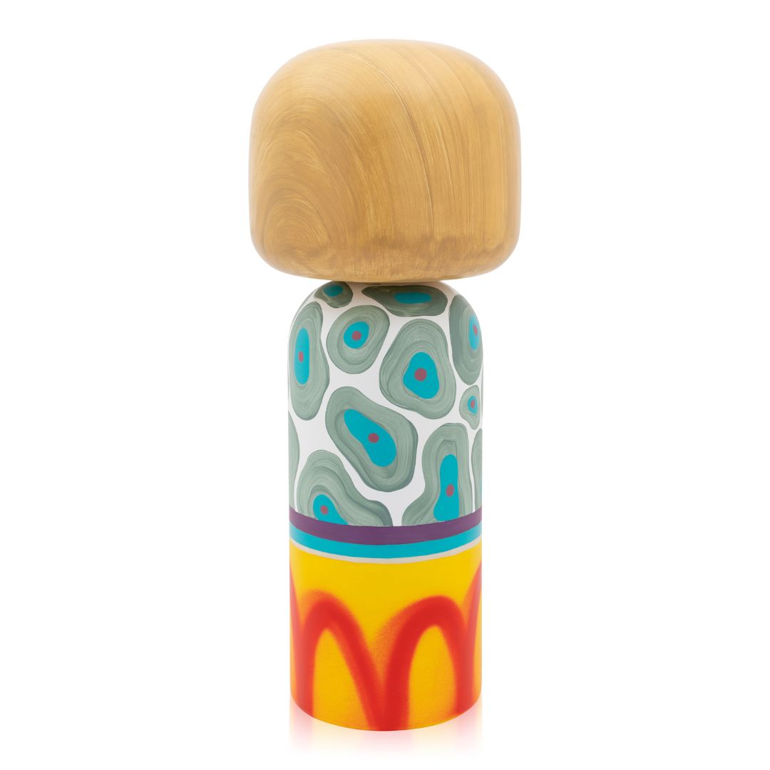 Eine farbenfrohe Kokeshi-Puppe mit einem Holzkopf und einem gemusterten Körper mit abstrakten Motiven.