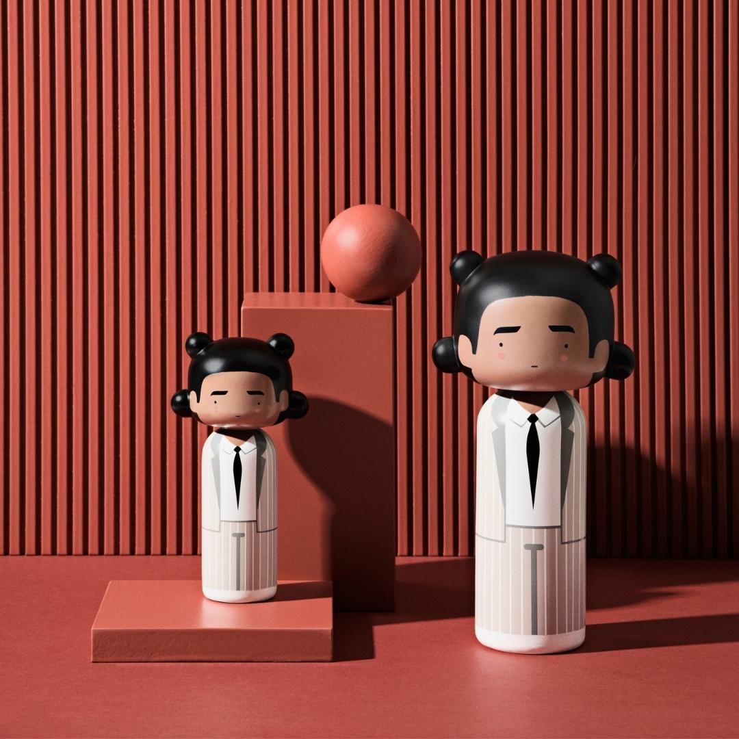 Deux poupées kokeshi en costume blanc sur un fond rouge texturé avec des formes géométriques.