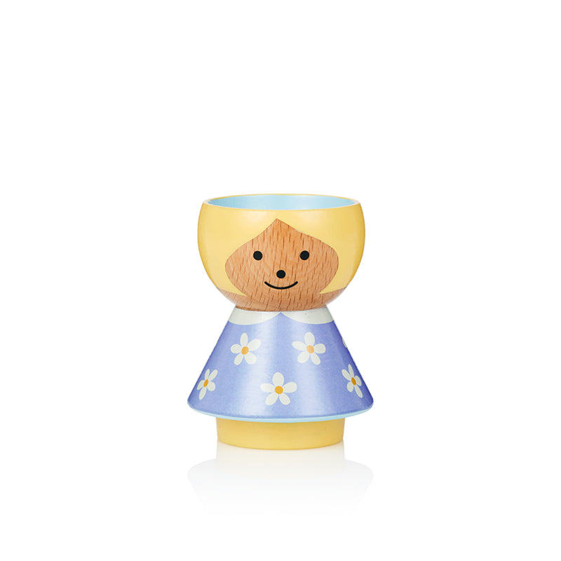 Coquetier en bois en forme de fille avec une tête jaune et une robe bleue avec des fleurs blanches.