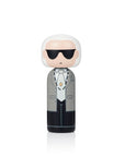 Une poupée kokeshi avec des cheveux blancs, des lunettes de soleil et un costume gris.