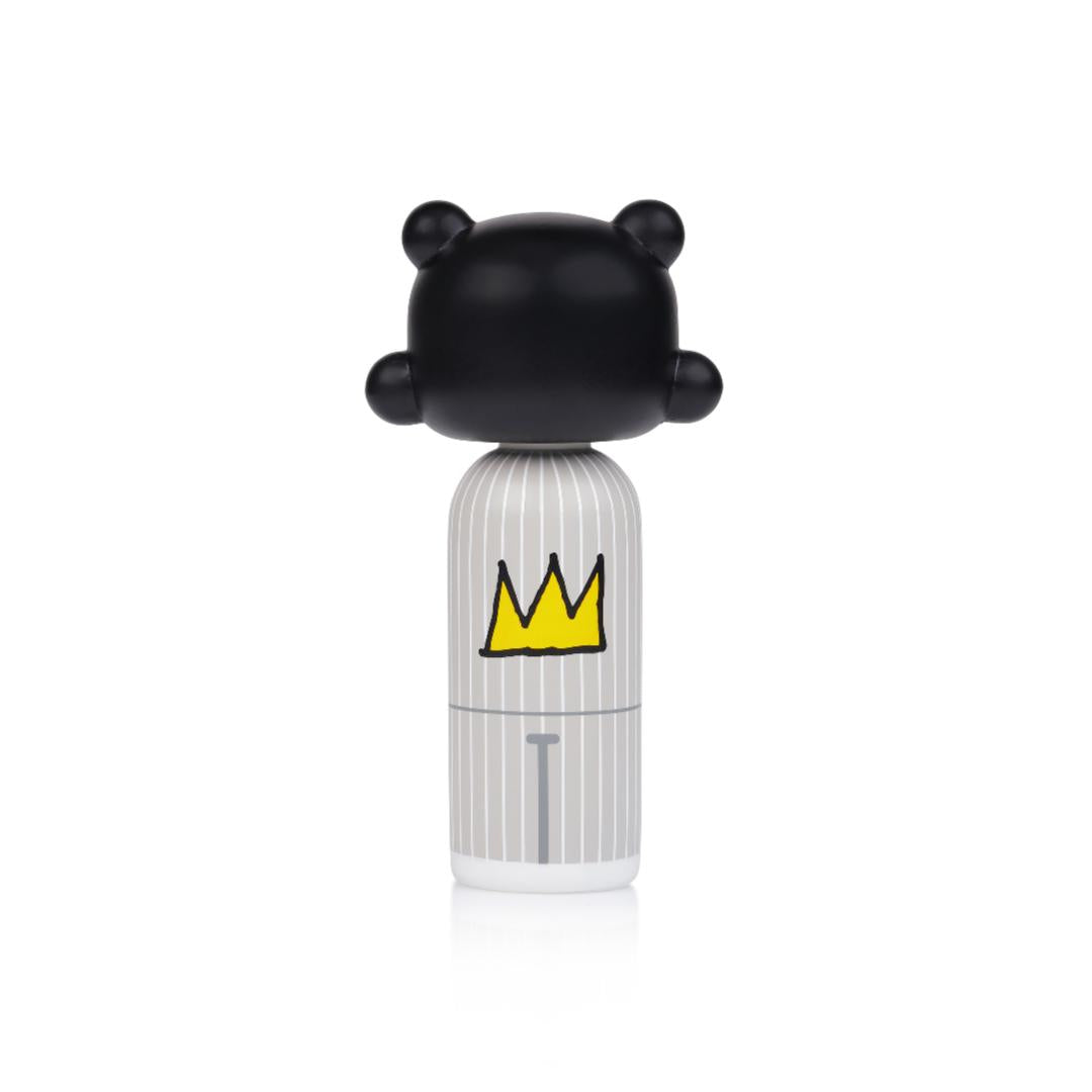 Poupée kokeshi avec une tête noire, un corps rayé et une couronne jaune sur le dos.