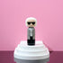 Lucie Kaas kokeshi doll inspired by a white-haired fashion icon wearing sunglasses on pink display