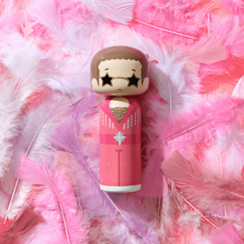 Kokeshi doll in a pink outfit with star-shaped eyes, surrounded by pink and white feathers.