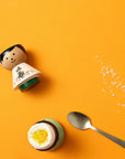 Egg Holder | Snufkin Free-spirited EGG HOLDER on yellow background with a soft boiled egg - Lucie Kaas