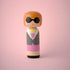 Lucie Kaas kokeshi doll with bob haircut, black sunglasses and grey coat on pink background