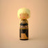Lucie Kaas kokeshi doll with blonde bob and black strappy outfit on neutral background