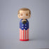 Lucie Kaas kokeshi doll wearing a star-spangled blue jacket, heart chest hair detail and red-striped trousers