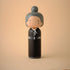Lucie Kaas wooden kokeshi doll in black kimono with grey bun hairstyle, minimalist design