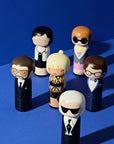 A  selection of Lucie Kaas' kokeshi dolls on a dark blue background