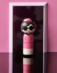 Lucie Kaas' Jackie Kokeshi Doll in a Doorway and pink background