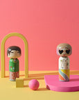 Mira Mikati und Gio Kokeshi-Puppen aus der Mira Mikati-Kollektion von Lucie Kaas in einem orangefarbenen Rahmen mit rosa Verzierungen