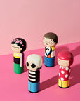 Eine Sammlung von Kokeshi-Puppen auf einem rosa Hintergrund