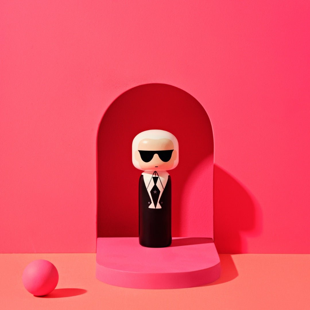 Karl Kokeshi doll in front of a pink background